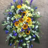 Standing floral spray with sunflowers, lilies, and purple blooms