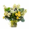 Yellow roses and white flowers in a glass vase with a ribbon