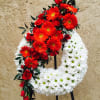 Red and white floral funeral wreath on a stand