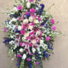 Large standing spray of pink lilies, white roses, and blue flowers