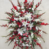 Large red, white, and pink funeral spray with lilies and daisies