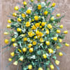 Large standing spray of yellow roses with white filler flowers