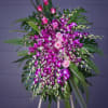Tall floral spray with pink roses and purple orchids on an easel