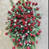 Large standing spray of red roses with white filler flowers
