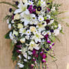 Large standing floral spray with white lilies, daisies, and purple accents