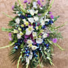 Large standing floral spray with white lilies, calla lilies, and purple blooms