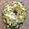 Yellow and white floral wreath on a stand