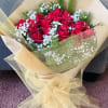 Bouquet of red roses with white baby's breath wrapped in beige tulle