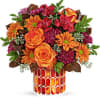 Orange roses and daisies in a patterned vase