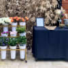 Flower display on a gold rack beside a navy-draped table with small bouquets and decor