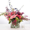 Mixed pink and purple flowers arranged in a glass vase