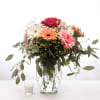 Mixed gerbera bouquet in a glass vase with a small candle