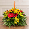 Colorful floral centerpiece with a tall orange taper candle