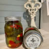 Two jars of pickles on a countertop, one upright and one lying on its side