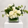 White roses and hydrangeas arranged in a square glass vase