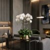 White orchids in a gold pot on a table in a modern living room