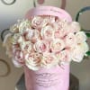 Round pink hat box filled with pale pink roses