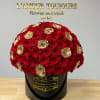 Round bouquet of red and gold roses in a black hatbox