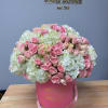 Pink roses and white hydrangeas in a pink hat box with ribbon