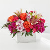 Mixed bouquet of orange roses, lilies, and pink daisies in a white box