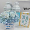 Blue and white flower arrangement in a white container with a baby card