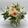 White and peach mixed bouquet in a clear glass vase