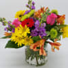 Mixed bouquet of colorful flowers in a clear glass vase