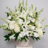 White lilies and roses in a woven basket arrangement
