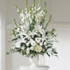 White floral arrangement in a white pedestal vase