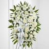 White floral standing spray with roses and lilies on an easel