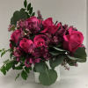 Pink roses and purple flowers arranged in a white vase