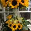 Sunflower arrangement with yellow orchids in a black box