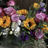 Bouquet of pink roses, sunflowers, and white flowers in a vase