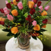 Mixed rose arrangement in a decorative glass vase