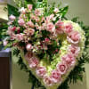 Large pink rose and lily funeral spray on an easel