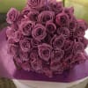 Bouquet of purple roses wrapped in purple paper