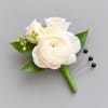 White floral boutonniere with green leaves and berry accents