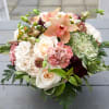 Peach and white floral bouquet with roses and orchids