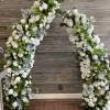 Large white floral arch with roses and hydrangeas