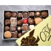 Box of assorted chocolates with a yellow lid partially covering it