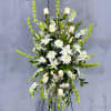 Tall white floral spray on a stand with green accents