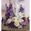 Purple and white floral arrangement with a praying angel figurine