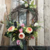 Floral wreath with pink and cream blooms on a twig base