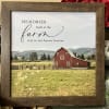 Framed farm sign with a red barn and red roses behind it