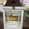 A large rustic lantern with a beautiful barn and verse  inside.