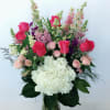 Mixed pink and white flowers arranged in a glass vase