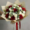 Bouquet of red roses and white carnations wrapped in beige paper
