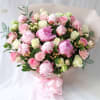Bouquet of pink and white peonies and roses with a pink ribbon