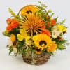 Basket arrangement with sunflowers, orange roses, and yellow daisies