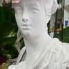 White bust wearing a pastel flower crown with pink and white blooms